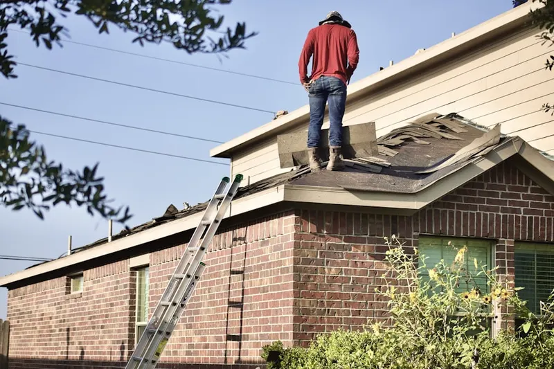 Professional roofer working on a residential roof in Whitaker Farms